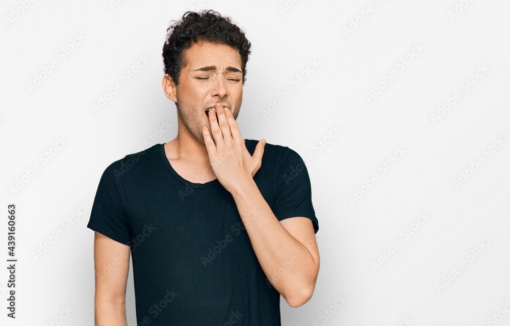 Young handsome man wearing casual black t shirt bored yawning tired covering mouth with hand. restless and sleepiness. Young handsome man wearing casual black t shirt bored yawning tired covering mouth with hand. restless and sleepiness.