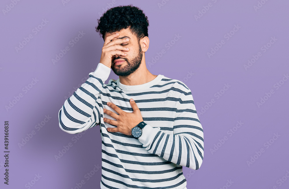 Young arab man with beard wearing casual striped sweater touching forehead for illness and fever, flu and cold, virus sick Young arab man with beard wearing casual striped sweater touching forehead for illness and fever, flu and cold, virus sick