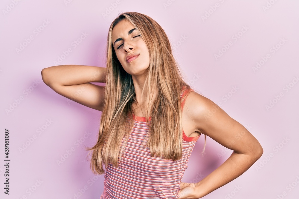 Beautiful hispanic woman wearing casual summer t shirt suffering of neck ache injury, touching neck with hand, muscular pain Beautiful hispanic woman wearing casual summer t shirt suffering of neck ache injury, touching neck with hand, muscular pain