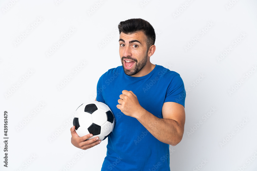 Handsome young football player man over isolated wall celebrating a victory Handsome young football player man over isolated wall celebrating a victory