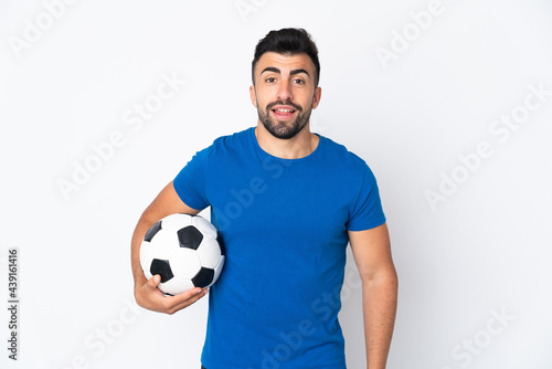 Handsome young football player man over isolated wall posing with arms at hip and smiling