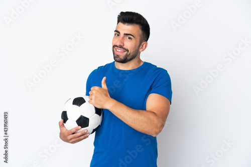 Handsome young football player man over isolated wall giving a thumbs up gesture © luismolinero