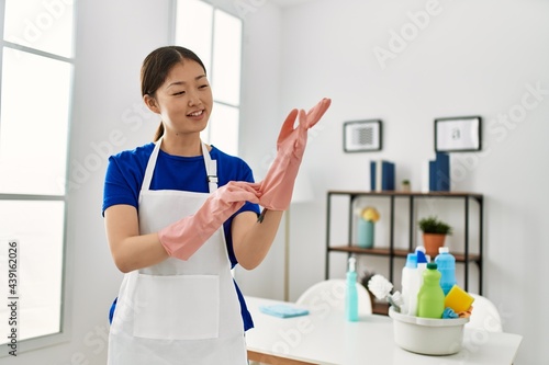 Young chinese housewife put in gloves at home.