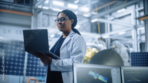 Tableau sur toile Portrait of Brilliant Female Engineer Confident and Focused Thinking, working at Aerospace Satellite Manufacturing Facility