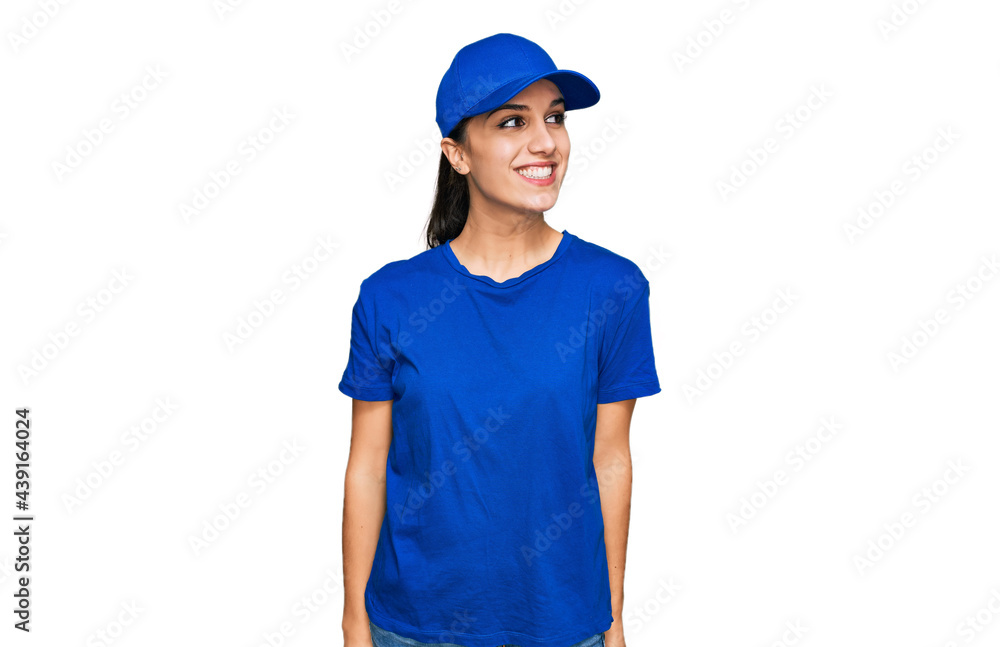 Young hispanic girl wearing delivery courier uniform looking away to side with smile on face, natural expression. laughing confident. Young hispanic girl wearing delivery courier uniform looking away to side with smile on face, natural expression. laughing confident.