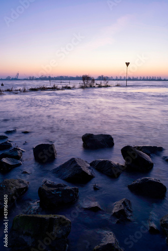 Sunrise above some rocks in the Merwede photo