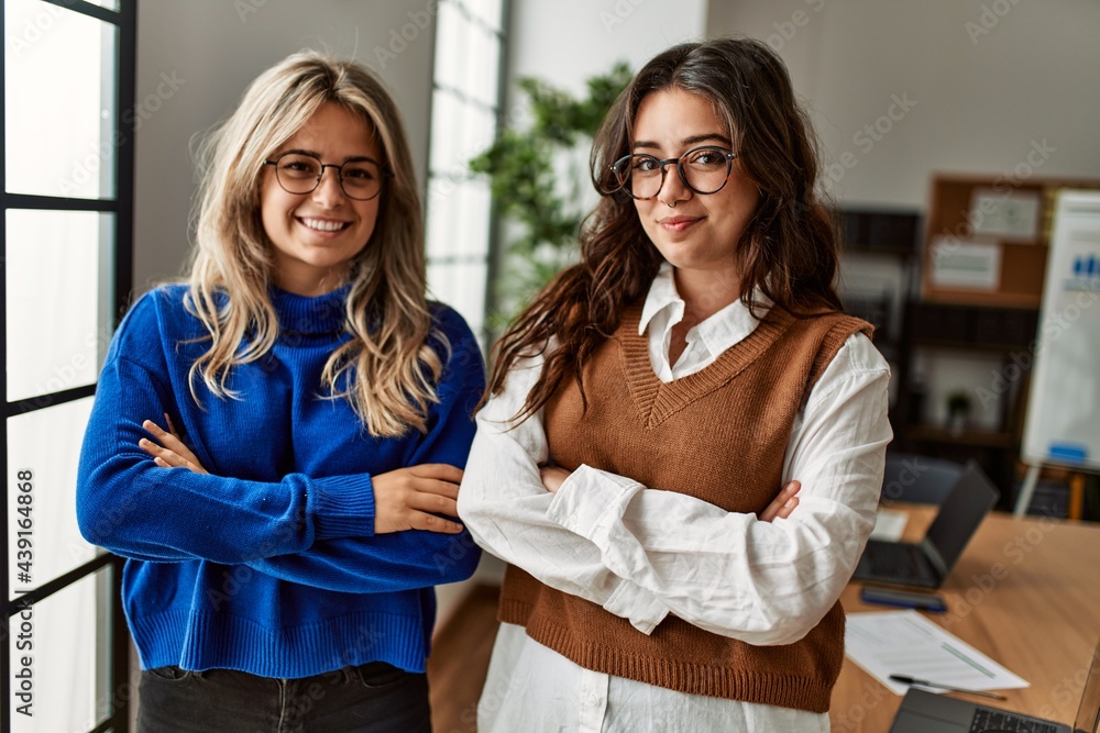 Two business workers woman smiling happy standing with arms crossed gesture at the office. Two business workers woman smiling happy standing with arms crossed gesture at the office.