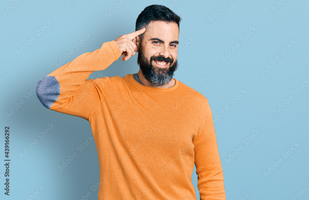 Hispanic man with beard wearing casual winter sweater smiling pointing to head with one finger, great idea or thought, good memory Hispanic man with beard wearing casual winter sweater smiling pointing to head with one finger, great idea or thought, good memory
