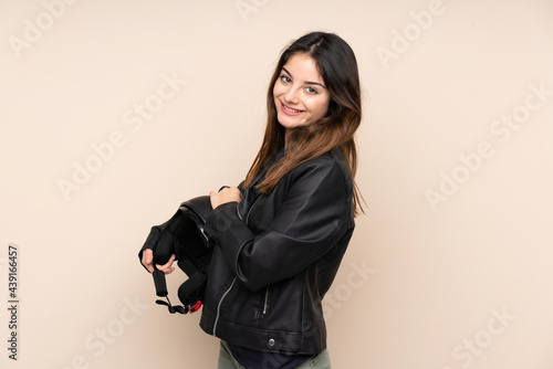 Woman with a motorcycle helmet isolated on beige background laughing © luismolinero