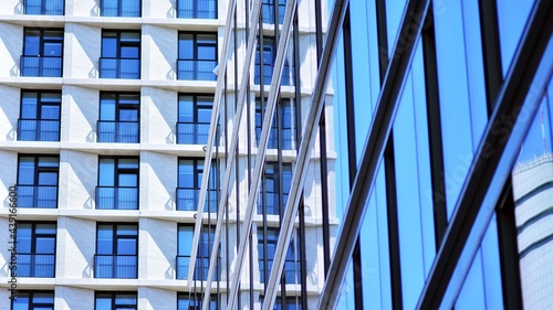 A residential building and an adjacent office building. Modern urban development. Buildings against blue sky