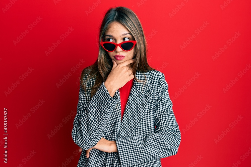 Young brunette woman wearing fashion and modern look with hand on chin thinking about question, pensive expression. smiling with thoughtful face. doubt concept. Young brunette woman wearing fashion and modern look with hand on chin thinking about question, pensive expression. smiling with thoughtful face. doubt concept.