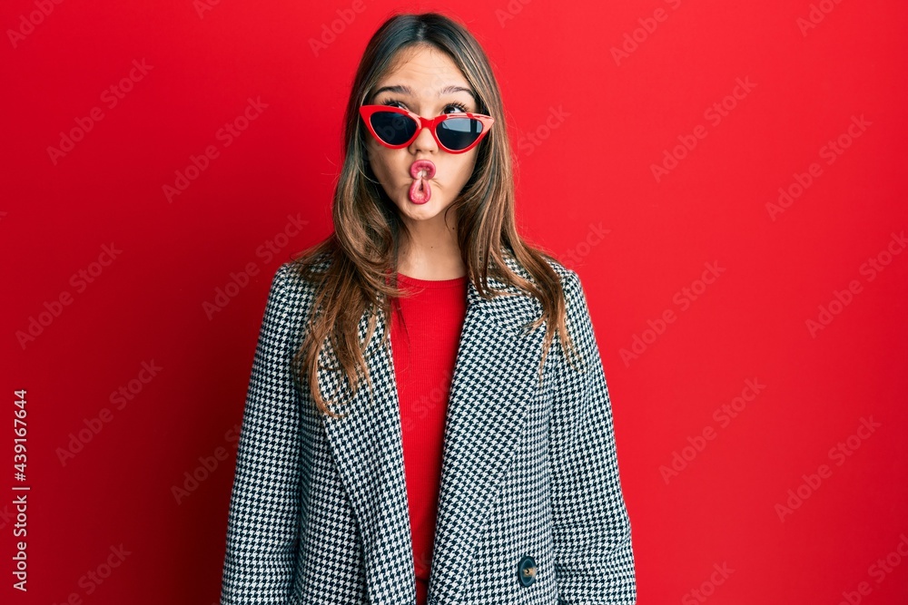 Young brunette woman wearing fashion and modern look making fish face with lips, crazy and comical gesture. funny expression. Young brunette woman wearing fashion and modern look making fish face with lips, crazy and comical gesture. funny expression.