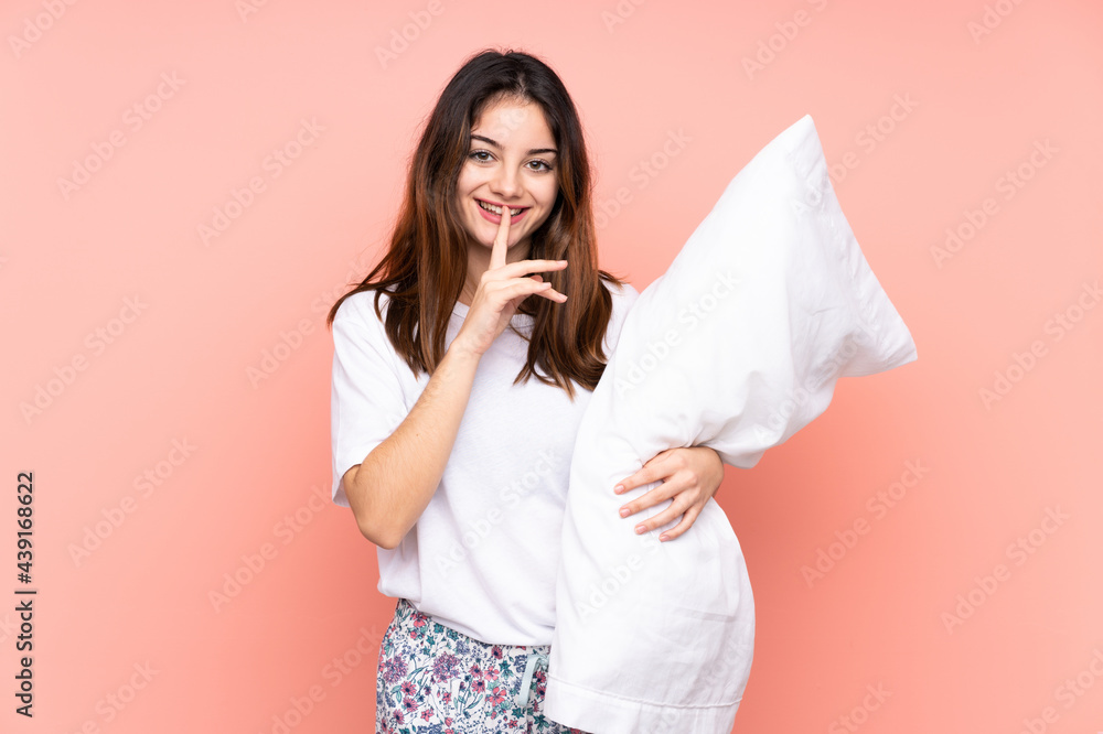 Young woman in pajamas isolated on pink background doing silence gesture Young woman in pajamas isolated on pink background doing silence gesture