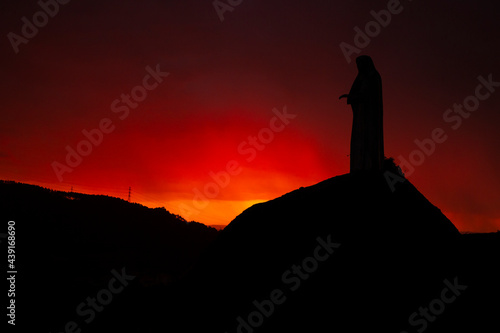 Silhouette of The Virgin Mary Statue in Pilar Mountain, Povoa de Lanhoso, Braga, during a Sunset in a Stormy Day.