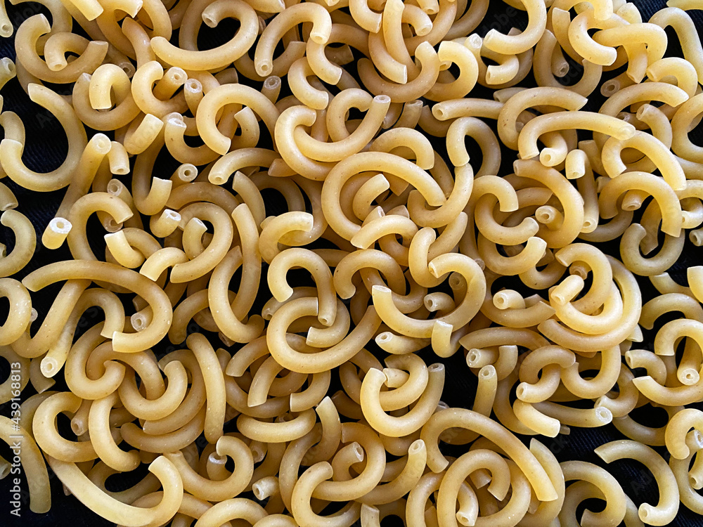 Raw Gramigna Pasta on dark background. Top view Raw Gramigna Pasta on dark background. Top view