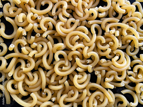 Raw Gramigna Pasta on dark background. Top view photo