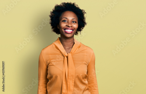 African american woman with afro hair wearing elegant shirt looking positive and happy standing and smiling with a confident smile showing teeth © Krakenimages.com