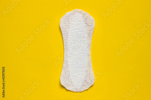 Feminine hygiene panty liner for menstruation. Menstrual cycle, pad. Yellow background. red strawberry.