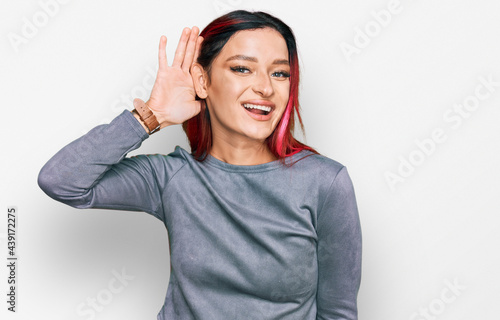 Young caucasian woman wearing casual clothes smiling with hand over ear listening an hearing to rumor or gossip. deafness concept.