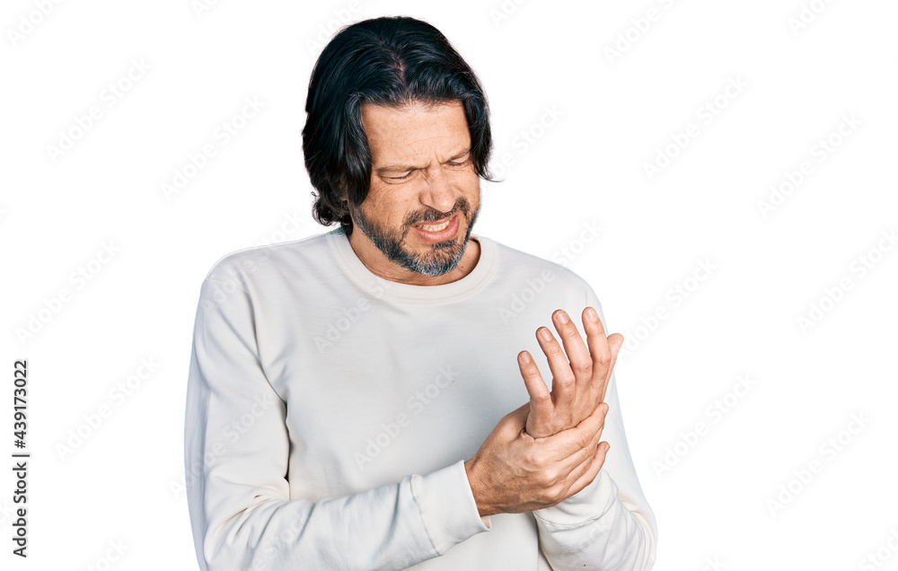 Middle age caucasian man wearing casual clothes suffering pain on hands and fingers, arthritis inflammation Middle age caucasian man wearing casual clothes suffering pain on hands and fingers, arthritis inflammation