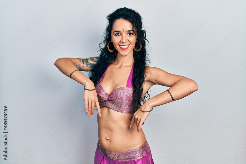Fototapeta premium Young indian woman wearing traditional belly dancer costume. Dancing exotic oriental dance with body and hands