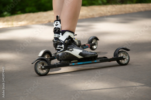 A man on a roller ski rides in the park.Cross country skilling.