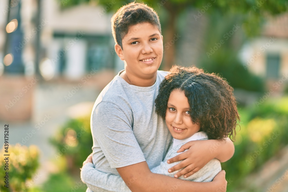 Adorable latin brother and sister hugging at the park. Adorable latin brother and sister hugging at the park.