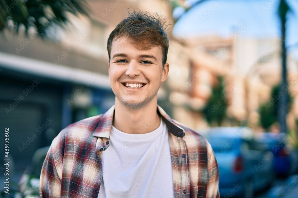 Fototapeta premium Young caucasian man smiling happy standing at the city.