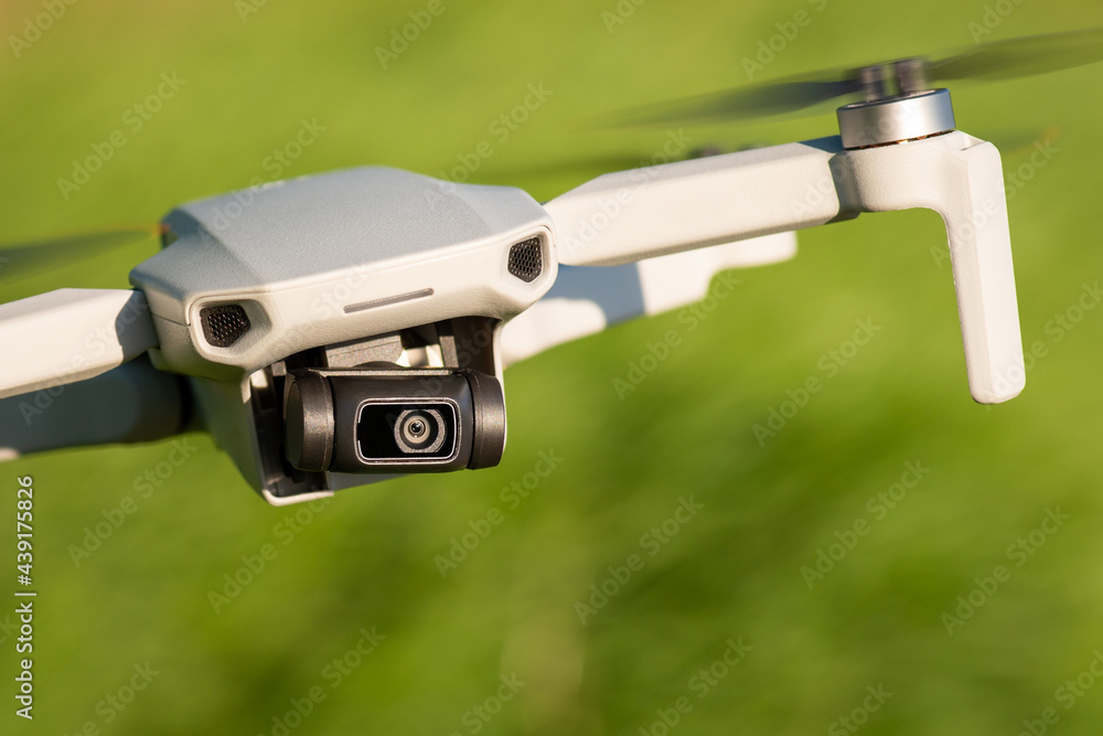 Close-up view of small professional drone filming video and flying to the side. Shooting video with a drone Close-up view of small professional drone filming video and flying to the side. Shooting video with a drone