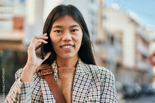 Young asian businesswoman smiling happy using smartphone at the city.