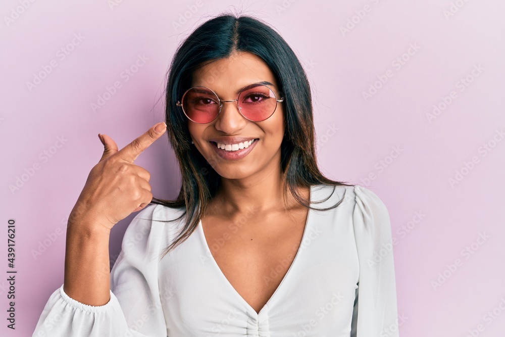 Young latin transsexual transgender woman wearing heart shaped sunglasses smiling happy pointing with hand and finger Young latin transsexual transgender woman wearing heart shaped sunglasses smiling happy pointing with hand and finger