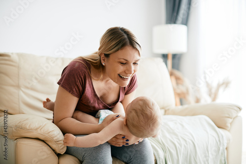 Young loving mother having fun with her baby at home.