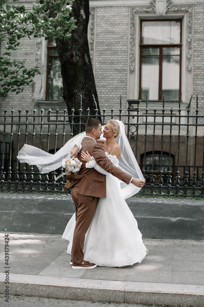hugs of the bride and groom on the street