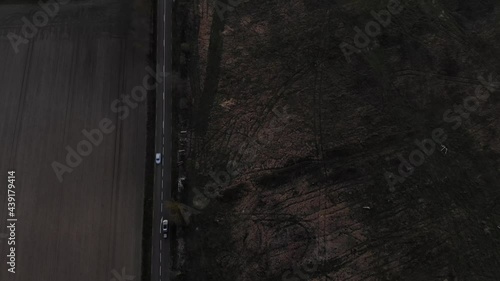 Roads in countryside, early low light day. Aerial shot of cars on road near field at dawn or dusk night. Aerial dark moody shot of road with cars. Copy space and black background.