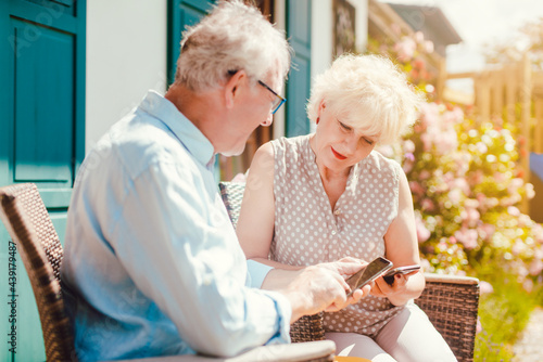 Senior couple looking at their phone in the garden