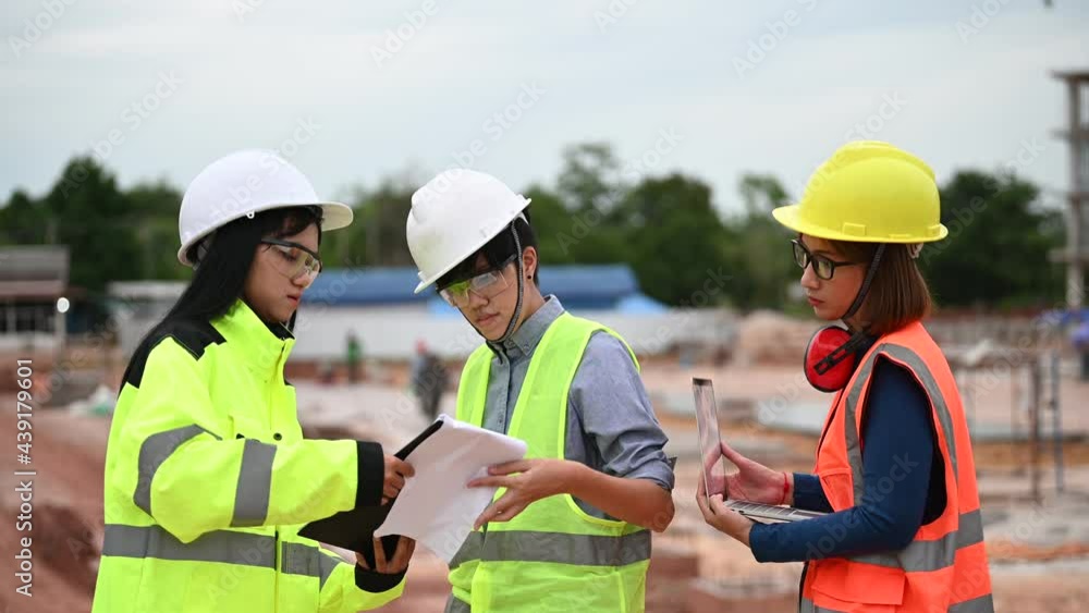 Young and senior Engineers discuss about work of large building underconstruction,Three people working on site of under construction Young and senior Engineers discuss about work of large building underconstruction,Three people working on site of under construction