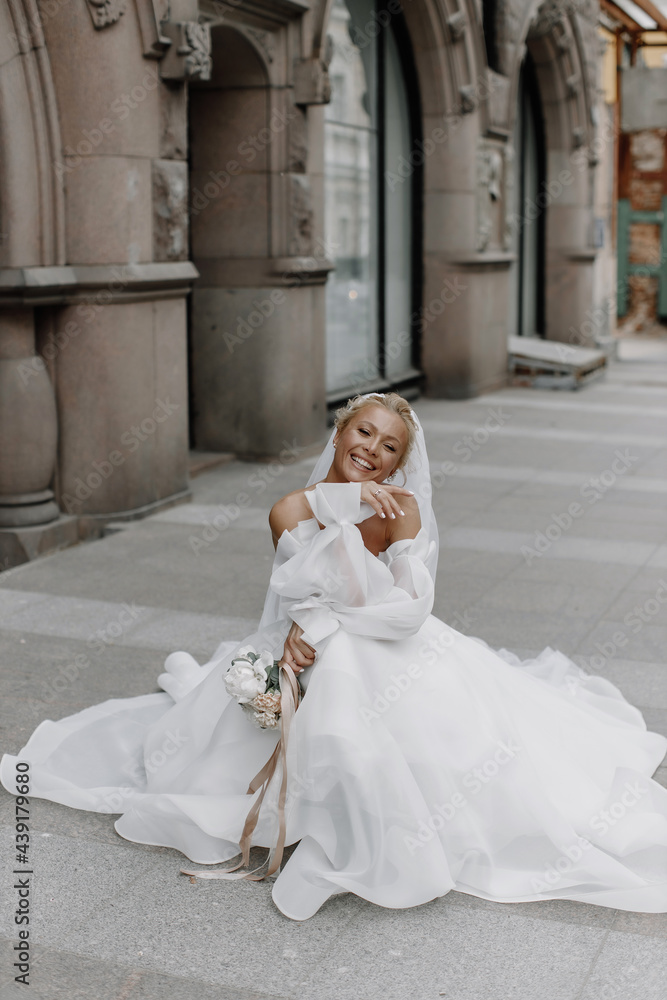 Obraz premium the bride in a wedding dress is sitting on the floor