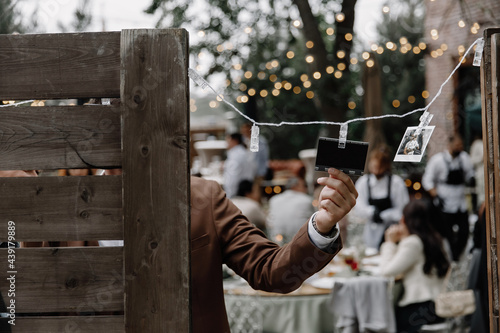 the groom hangs a palaroid snapshot on the board photo