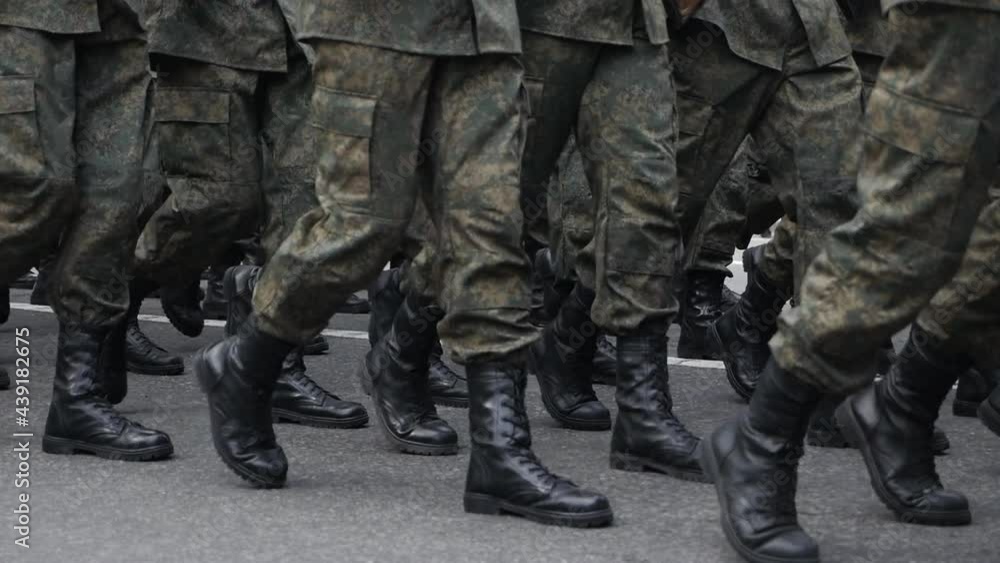 Close-up of legs and feet of military men marching down the street during the daytime parade in honor of veterans and military service. slow motion Close-up of legs and feet of military men marching down the street during the daytime parade in honor of veterans and military service. slow motion