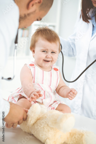 Happy girl-child at usual medical inspection. Doctor and female toddler patient in the clinic. Healthcare concept