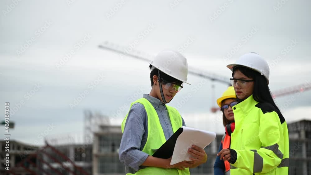 Young and senior Engineers discuss about work of large building underconstruction,Three people working on site of under construction Young and senior Engineers discuss about work of large building underconstruction,Three people working on site of under construction