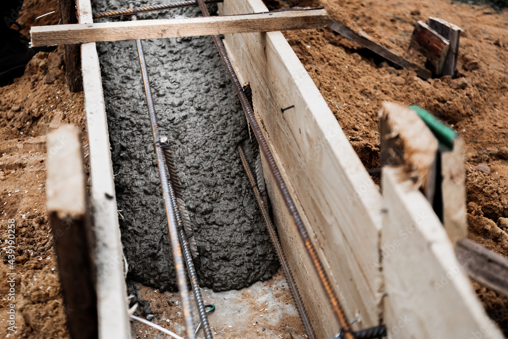 Timber formwork with metal reinforcement for pouring concrete and creating a solid foundation for a building or fence. Construction process Timber formwork with metal reinforcement for pouring concrete and creating a solid foundation for a building or fence. Construction process