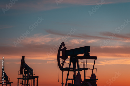 Oil rocking towers. Sunset at the oil pipeline. 