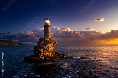 The beautiful Lighthouse Tourlitis of Chora at night. Andros island, Cyclades, Greece