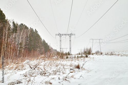 Electrical tower in wintertime with snow covered field