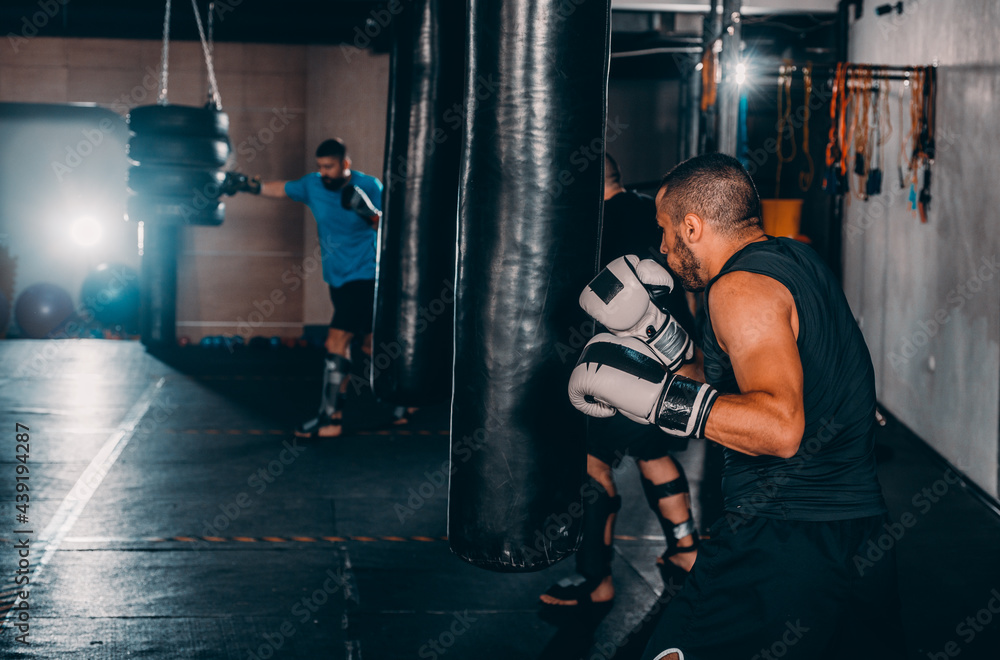 Hispanic MMA Fighter practicing some kicks with a punching bag