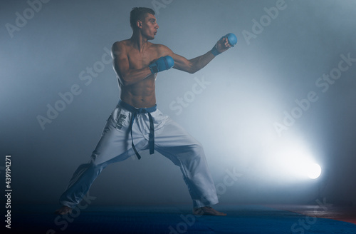 The man in a kimono practicing karate moves