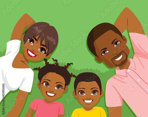 Happy four members black family lying on grass together