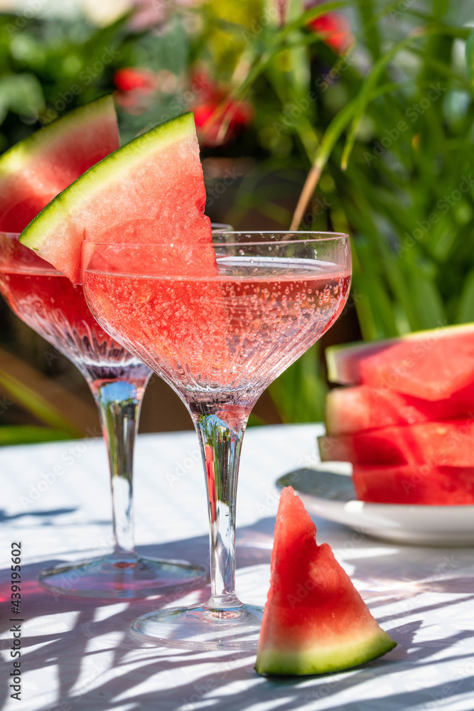 Bubbly champagne cocktail garnished with slides of watermelon Bubbly champagne cocktail garnished with slides of watermelon