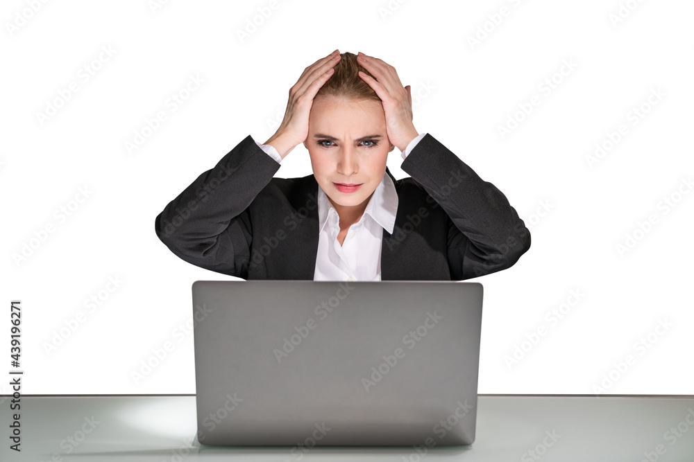 Portrait of attractive thoughtful young business woman in formal clothes isolated on white background sitting on desk and working on laptop and holds her head by both hands. Concept of headache Portrait of attractive thoughtful young business woman in formal clothes isolated on white background sitting on desk and working on laptop and holds her head by both hands. Concept of headache